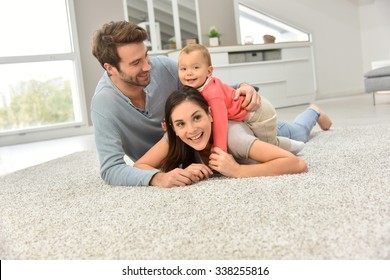 Parents And Baby Girl Laying On Carpet, 