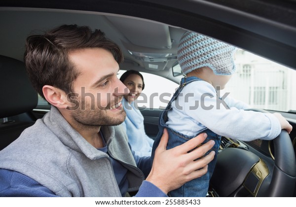 Parents and baby on a\
drive in their car