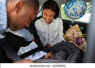 Parents Bringing Newborn Baby Home In Car