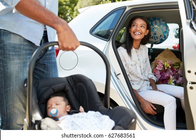 Parents Bringing Newborn Baby Home In Car