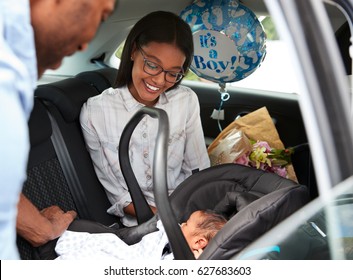 Parents Bringing Newborn Baby Home In Car