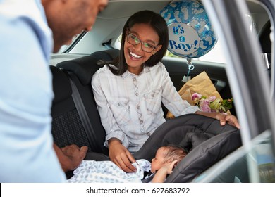 Parents Bringing Newborn Baby Home In Car