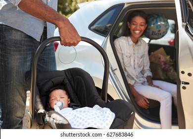 Parents Bringing Newborn Baby Home In Car