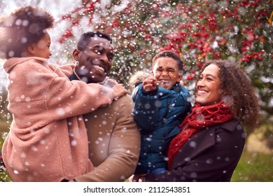 Parents Carrying Children As Family Enjoy Fall Or Winter Walk In Countryside In Snow