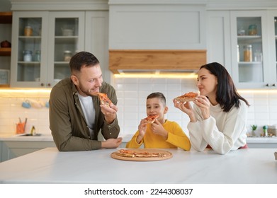 Parents and child eating pizza in living-room at home - Powered by Shutterstock
