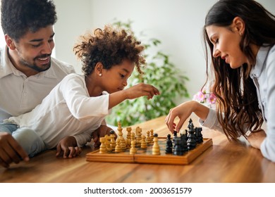 Parents and child playing chess while spending time together at home. Family love education concept - Powered by Shutterstock