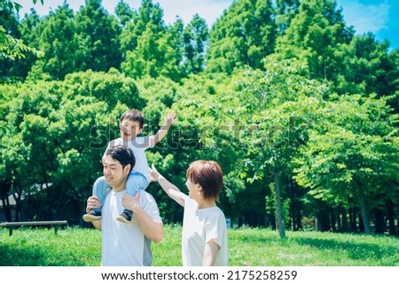 Parents and child playing while piggybacking in the park