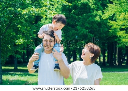 Parents and child playing while piggybacking in the park