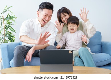 Parents And Child Waving Toward The Screen Of A Tablet PC