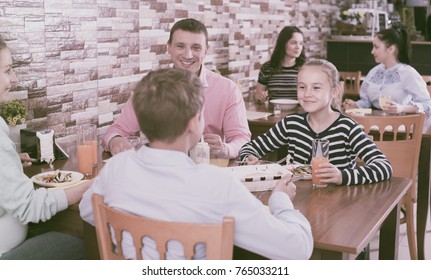 Parents With Children Dining Together In Modern Family Restaurant