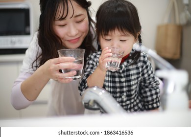 Parents And Children Drinking Tap Water