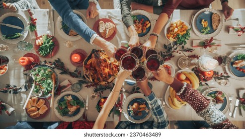 Parents, Children and Friends Enjoying Christmas Dinner Together in a Cozy Home. Relatives Sharing Meals, Raising Glasses with Red Wine, Toasting, Celebrating a Holiday. Top Down View - Powered by Shutterstock