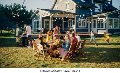 Parents, Children and Friends Gathered at a Barbecue Dinner Table Outside a Beautiful Home. Old and Young People Have Fun, Eat and Drink. Garden Party Celebration in a Backyard. - Shutterstock ID 2227481145