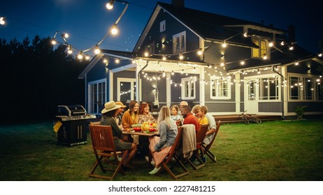 Parents, Children and Friends Gathered at a Barbecue Dinner Table Outside a Beautiful Home with Lights Decorations. Old and Young People Have Fun and Eat Food. Garden Party Celebration in a Backyard. - Shutterstock ID 2227481215