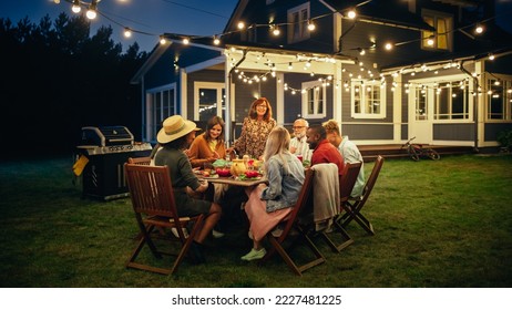 Parents, Children and Friends Gathered at a Barbecue Dinner Table Outside a Beautiful Home with Lights Decorations. Old and Young People Have Fun and Eat Meals. Garden Party Celebration in a Backyard. - Shutterstock ID 2227481225