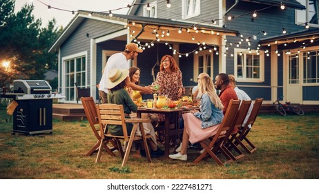 Parents, Children and Friends Gathered at a Barbecue Dinner Table Outside a Beautiful Home. Old and Young People Have Fun, Eat and Drink. Garden Party Celebration in a Backyard. - Powered by Shutterstock