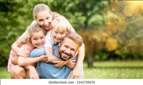 Parents And Children As Happy Family Hugging In Spring