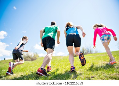 Parents With Children Sport Running Together Outside