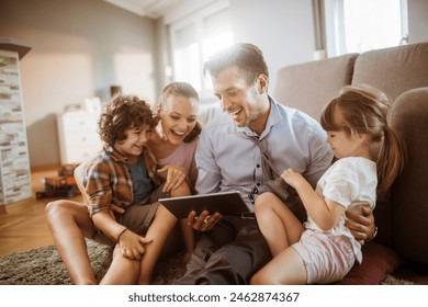 Parents and children using tablet on living room sofa - Powered by Shutterstock