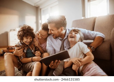 Parents and children using tablet on living room sofa - Powered by Shutterstock