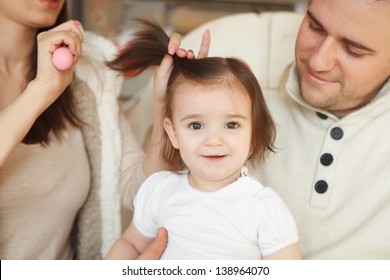 Parents combing they baby's hair