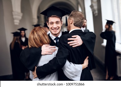 Parents congratulate the student, who finish their studies at the university. He graduates. They are very happy about this. - Shutterstock ID 1009751866