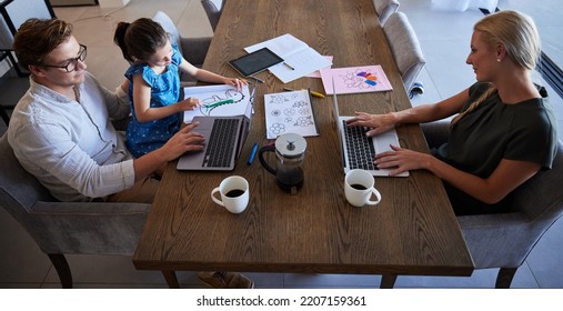 Parents And Daughter Being Productive With Remote Work And Homework, Multitasking At Table In Their Home. Startup, Business Owner And Child Doing Online Task In A Busy House With Little Girl Drawing