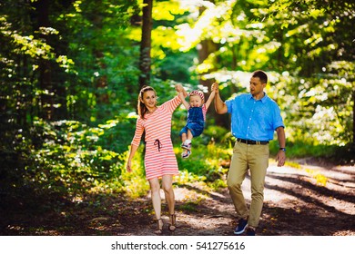 The parents with daughter walking along park