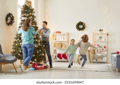 Parents decorate a Christmas or New Year tree at home while children playing nearby. The family enjoys the holiday together, with anticipation and joy filling the house as they celebrate. - Powered by Shutterstock