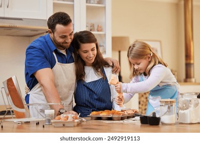 Parents, girl and baking in kitchen in home with batter ingredients for muffins, dessert and cupcakes recipe. Support, happy people and kid decorate cake for learning, helping and culinary education - Powered by Shutterstock