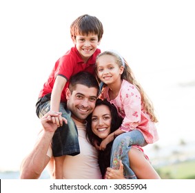 Parents giving children piggyback rides outdoors - Powered by Shutterstock