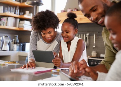 Parents Helping Children With Homework In Kitchen - Powered by Shutterstock