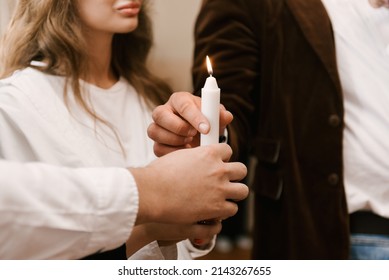 Parents hold a candle during the rite of baptism in the church
