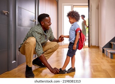 Parents At Home Helping Son Getting Ready To Go To School Putting On Shoes - Powered by Shutterstock