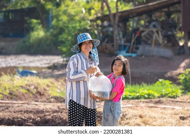 Parents And Kid Holding Plastic Bag Of Little Fish For Release The Fish To Pond