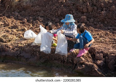 Parents And Kid Holding Plastic Bag Of Little Fish For Release The Fish To Pond