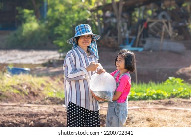 Parents And Kid Holding Plastic Bag Of Little Fish For Release The Fish To Pond