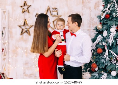 Parents And Kid In Santa Costume On Christmas Photoshoot