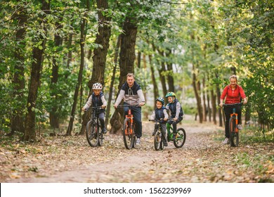 parents and kids cycling on forest trail. Young family in warm clothes cycling in autumn park. Family mountain biking on forest. Theme family active sports outdoor recreation. - Powered by Shutterstock