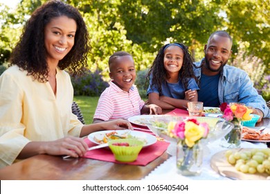 Parents And Kids Having A Lunch Together In The Garden