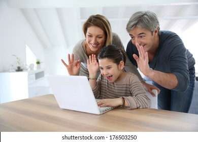 Parents with kids making a distant call on internet