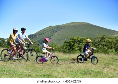 Parents With Kids Riding Bikes In Moutain Path