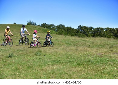 Parents With Kids Riding Bikes In Moutain Path