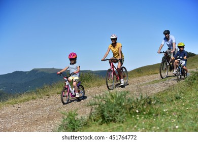 Parents With Kids Riding Bikes In Moutain Path