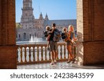 Parents with kids in Sevilla enjoy view of magnificent plaza de Espana in sunset light during their summer vacations in Spain