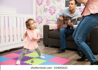 Parents Making Her Cute Child Show Her Dance Moves With Some Music Played By Her Dad With An Acoustic Guitar