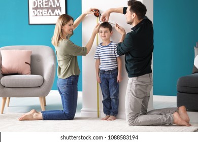 Parents measuring height of their son at home - Powered by Shutterstock