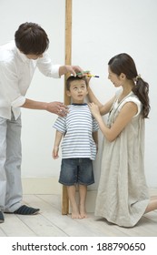 Parents Measuring Son's Height