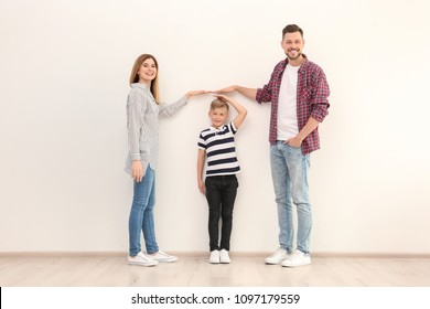 Parents measuring their son's height indoors - Powered by Shutterstock