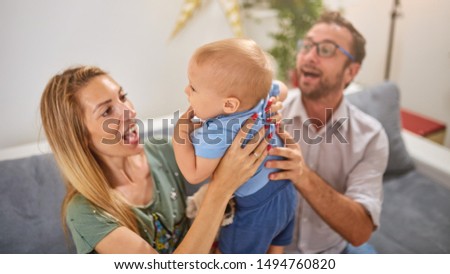 Parents playing with a baby at home.